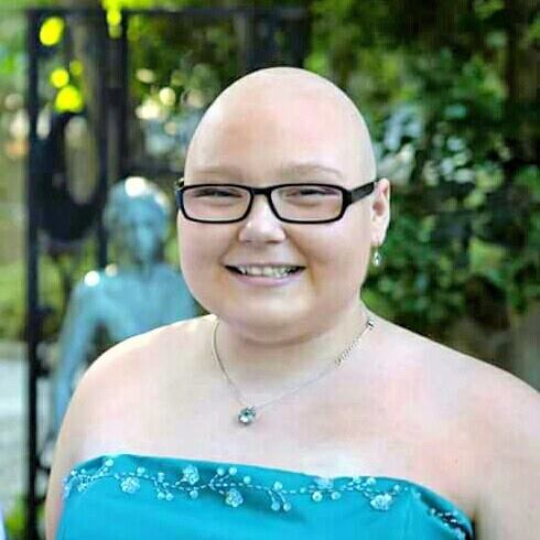 Lyndsey Jo Sexton smiling in a turquoise dress and wearing glasses